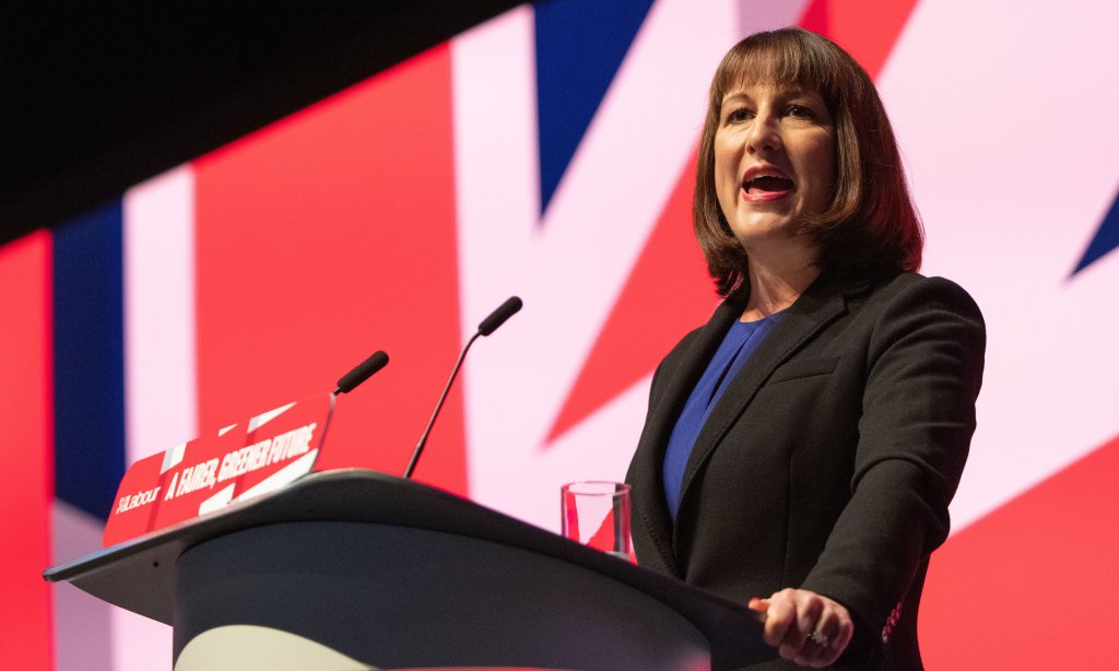 Photograph of Rachel Reeves speaking at a podium in front of a large British flag