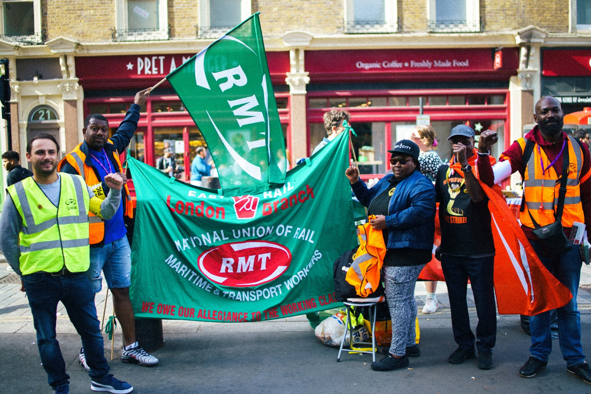 Photo of a group of picketing workers with RMT flags and banners