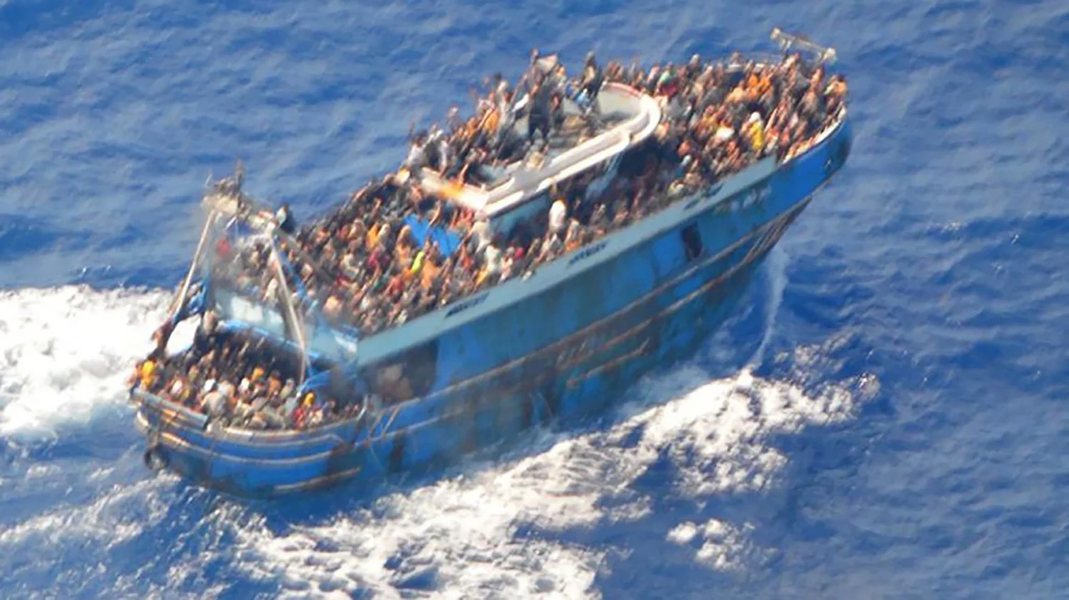 Migrants onboard a fishing vessel in the waters off the Peloponnese coast of Greece on Wednesday.