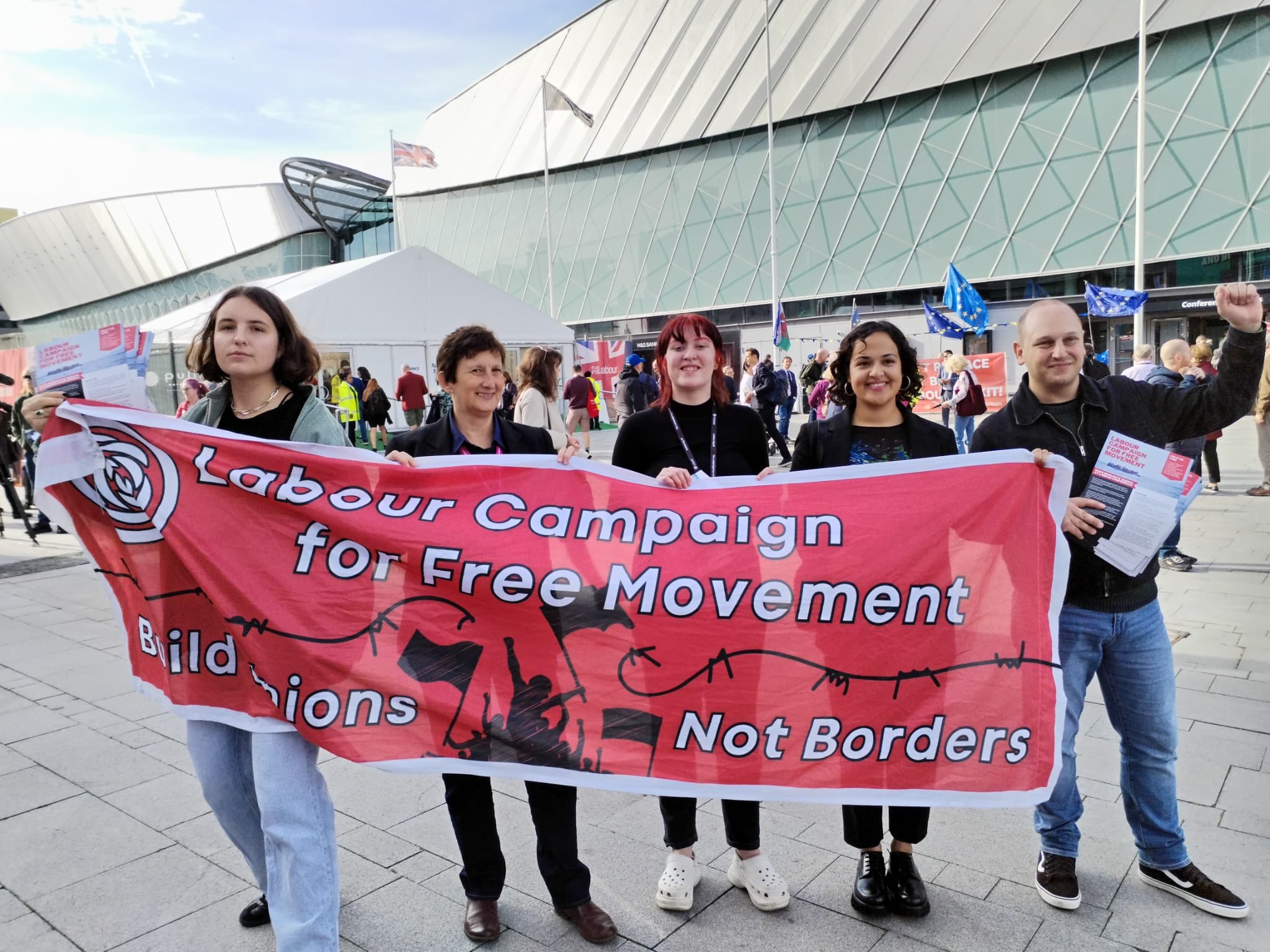 Campaigners outside Labour Party conference holding a banner reading "Labour Campaign for Free Movement" "Build Unions Not Borders"